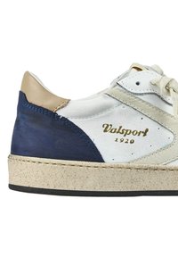 Sneaker bianca in pelle con accenti blu navy e beige, linguetta testurizzata, logo dorato "Valsport 1920" e suola in gomma di colore chiaro.