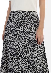Leopardprint nederdel, knælang, lavet af et tekstureret stof med et sort og lys grå mønster. Tætsiddende talje, afslappet A-formet silhuet.