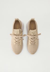 Beige gebreide sneakers met een gestructureerde afwerking, voorzien van ronde veters, een driehoekige logopatch en een witte rubberen zool.