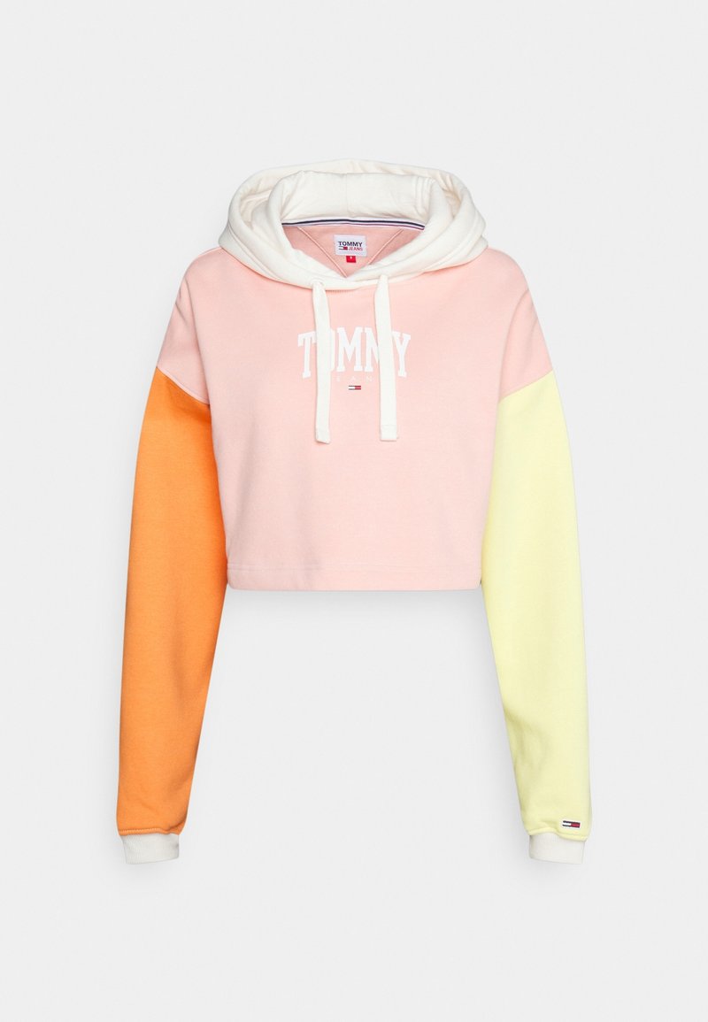 Kort hoodie med en mjuk blandning av pastellfärger: ljusrosa, orange och gul. Den har en dragsko i huvan och vit logotyptext.
