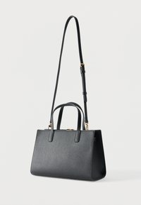 Μαύρη υφασμάτινη δερμάτινη τσάντα με διπλές επάνω λαβές και μακρύ ρυθμιζόμενο ιμάντα ώμου, εμφανιζόμενη σε απλό λευκό φόντο.