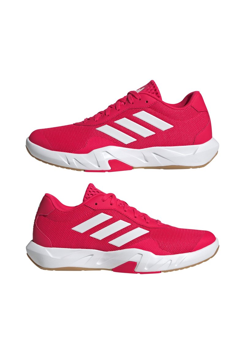 Des chaussures de sport rose vif avec un design à trois bandes blanches, un dessus en mesh, une semelle rembourrée et une semelle extérieure en caoutchouc naturel. Silhouette basse.