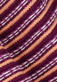 Tissu au crochet avec des rayures alternées de violet profond, d'orange pastel et de blanc. La texture est douce avec un motif tressé.