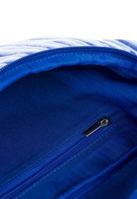 Niebieska torba materiałowa od wewnątrz z kieszonką na zamek błyskawiczny. Teksturowana podszewka i solidny zamek z metalowym uchwytem w kolorze srebrnym.