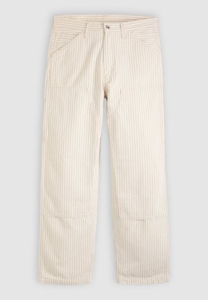 Bézs csíkos pamutnadrág egyenes szabással. Elöl zsebekkel és gombos záródással rendelkezik. A szöveten függőleges csíkmintázat található.