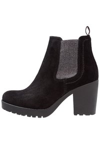 Svart suède ankelstövel med elastiska sidor, en kraftig klack och en texturerad svart gummisåle med zigzagmönster.