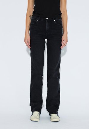 Schwarze Denim-Jeans mit geradem Bein, fünf Taschen, Knopfverschluss und dezenten Steppdetails. Tragen mit hellen Sneakers.