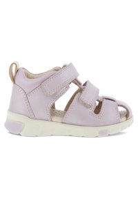 Lys lilla lædersandal med to velcro-stropper, åben tå-design, hvid sål med mønstrede detaljer og lille bagsløjfe for nem af- og påtagning.
