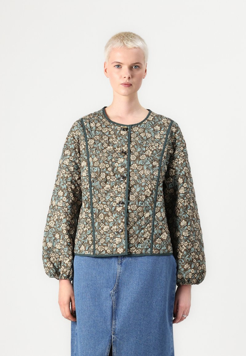 Gegoten jas met bloemenpatroon in bruin, crème en teal. Heeft een ronde halslijn, lange mouwen en een knopen sluiting.