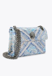 Sac à main décoratif bleu et argent avec une bandoulière en chaîne, présentant un motif clouté, un tissu texturé et un détail de fermoir décoratif.