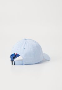 Căciulă de baseball de culoare albastru deschis cu o margine curbată, curea ajustabilă și detaliu brodat cu brand pe banda interioară. Material din bumbac moale.
