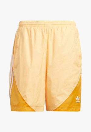 Oranger Satin-Trainingsanzug mit weißen Akzenten, der drei weiße Streifen an den Ärmeln und Shorts aufweist. Weiße Sneakers runden den Look ab.