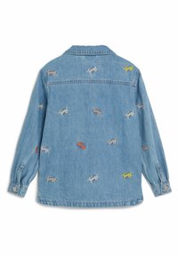 Chaqueta de mezclilla en azul claro con mangas largas, bordados de logos "Tommy" en rojo, amarillo y beige, con cierre de botones en el frente y cuello clásico.