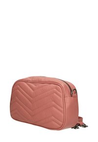 Borsa a tracolla in pelle rosa con motivo a zig zag trapuntato, hardware in argento, chiusura con zip e tracolla rimovibile. Forma rettangolare.