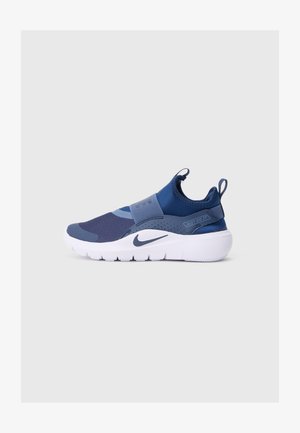 Sapatilha desportiva azul-marinho com painéis de malha, faixa elástica e calcanhar texturizado. Entressola branca com detalhe do logótipo preto e texto "JUST DO IT".