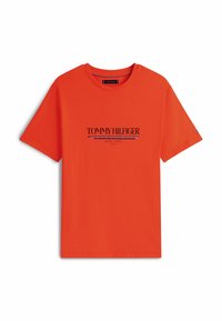 Camiseta de algodón naranja de manga corta, con cuello redondo, que presenta el logo de "TOMMY HILFIGER" en texto negro y azul en el pecho.