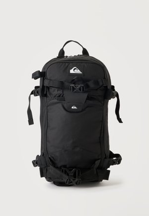 Juoda Quiksilver kuprinė su keliais skyriais, reguliuojamomis rankenomis ir sagtimis, rodoma vertikaliai ant paprasto šviesaus fono.