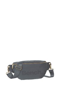 Grijze textiele schoudertas met gouden rits, met een prominent "Bench." logo. Eenvoudig, rechthoekig ontwerp met verstelbare schouderriem.