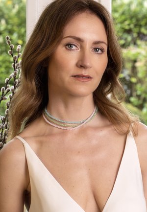 Meerkleurige ketting met strengen van pastelkleuren: blauw, groen, roze. Facet geslepen ronde kralen met een gladde textuur die dicht op elkaar zijn gerangschikt.