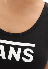 Débardeur noir avec un col arrondi, fabriqué en tissu doux, orné du grand texte blanc "VANS" sur la zone de la poitrine.