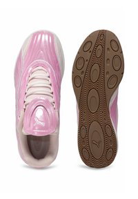 Rozā sporta apavi ar spīdīgu lakotu virsmu, teksturētām akcentiem, baltām acs paneļiem un brūnu gumijas zoli ar apļveida rakstiem.