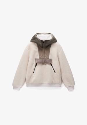 Polarowy sweter w kolorze off-white z kontrastowym panelem w oliwkowym zielonym i beżowym, z wysokim kołnierzem, zamkiem błyskawicznym oraz dwiema bocznymi kieszeniami.