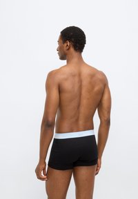 Μαύρα βαμβακερά αντρικά εσώρουχα boxer με ανοιχτό μπλε ζώνη μέσης Calvin Klein, με ομαλή υφή και εφαρμοστή σχεδίαση. Προβολή από πίσω.