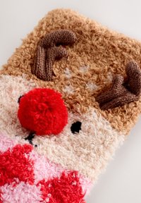 Laponų formos minkštas žaislas su pūkuota kreminės spalvos veiduku, raudona pompomo nosimi, rudais ragais ir rausvai-raudonu languotu raštu apačioje.