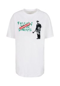 White cotton t-shirt featuring a graphic print of a man with tools, text reading "FOLLOW YOUR DREAMS" in green, crossed by a red "CANCELLED" stamp.