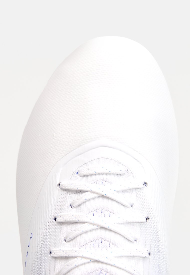 Weißer Sportschuh mit einem glatten, strukturierten Obermaterial, das eine runde Zehenform und ein Schnürsystem aufweist. Akzente sind kleine blaue Details in der Nähe der Schnürsenkel.