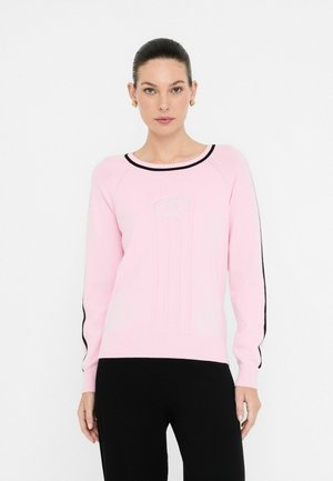 Roze gebreide trui met zwarte accenten, ronde halslijn, geribbelde textuur en geborduurd logo in het midden van de borst. Lange mouwen.