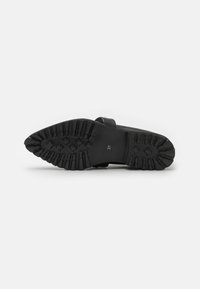 Suela de zapato de goma negra con un patrón texturizado para mayor agarre, que presenta un diseño elevado y la talla "37" en un lateral.