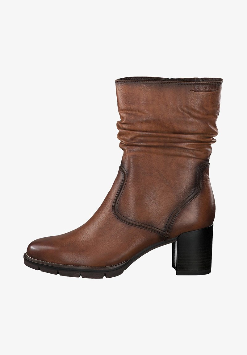 Bottine en cuir marron avec un talon bloc de 5 cm, bout rond et détail de tige plissée douce sur fond blanc.