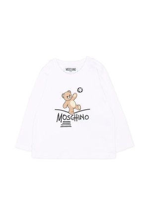 Biała koszulka niemowlęca z długim rękawem z grafiką misia bawiającego się piłką oraz tekstem "Moschino" nadrukowanym pod misiem.