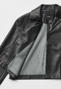 Zwarte leren jas met een gladde buitenkant, voorzien van een contrasterende lichtgrijze binnenkant, notched revers en twee knopen aan de voorkant.