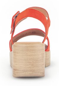 Oranje suède platform sandalen met een chunky, gestructureerde beige hak en twee kruislings bevestigde banden. Gesp detail op de enkelband.