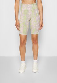 Dámské cyklistické šortky s vysokým pasem v světle růžové barvě se zeleným hadím vzorem, mají hladkou texturu a kontrastní boční pruhy.