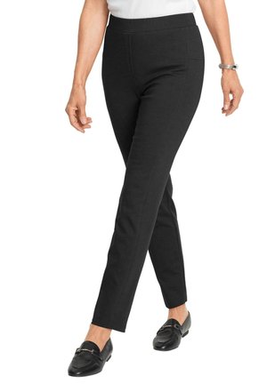 Zwarte stretchleggings met een slim fit, elastische tailleband en zijzakken. Soepele stof met een consistente textuur. Gestyleerd met zwarte instappers.