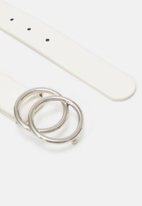 Witte leren riem met twee in elkaar grijpende zilveren metalen ringen als gesp, met meerdere gaatjes voor maatverstelling en een gladde afwerking.