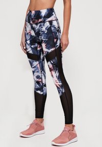 Leggings sportivi a vita alta con un motivo geometrico blu e rosa, dotati di pannelli in rete nera e realizzati in un tessuto morbido ed elasticizzato.