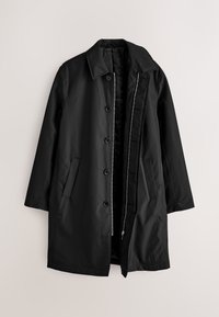 Manteau noir mi-long avec col, fermeture par boutons et zip, et poches latérales, posé à plat sur un fond clair.