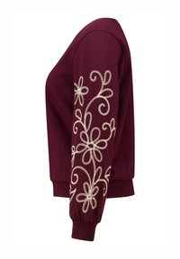 Bordeaux sweatshirt met decoratieve crèmekleurige bloemenborduursels op de linker mouw, met een ronde halslijn en geribbelde manchetten.