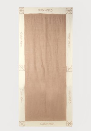 Țesătură dreptunghiulară bej și maro cu textul „Calvin Klein” și emblemă în colț pe margini crem, panou central maro simplu.