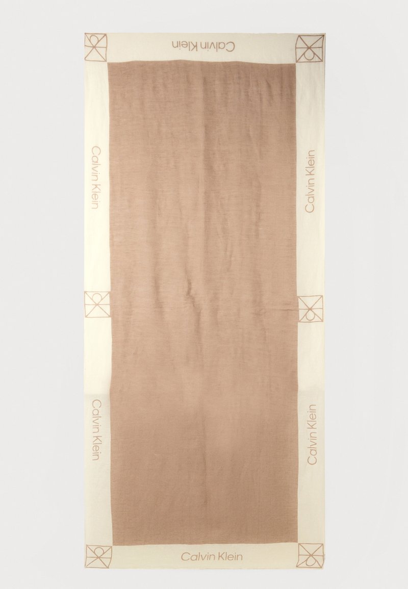 Ορθογώνιο ύφασμα σε μπεζ και καφέ χρώμα με το κείμενο "Calvin Klein" και έμβλημα στη γωνία στις κρεμ μπορντούρες, με μονόχρωμη καφέ κεντρική επιφάνεια.