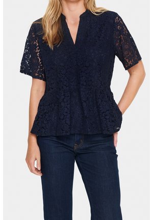 Marineblauwe kanten top met korte, gegolfde mouwen; heeft een v-hals en een peplumzoom. Getextureerd bloemenpatroon door de hele stof.