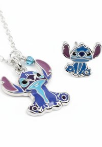Collier en argent et boucles d'oreilles clous présentant un personnage de dessin animé avec des accents en émail bleu et violet, contourné en métal poli.