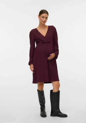 Robe portefeuille bordeaux en tissu texturé, manches longues et taille à nouer, assortie à des bottes noires à hauteur de genou.