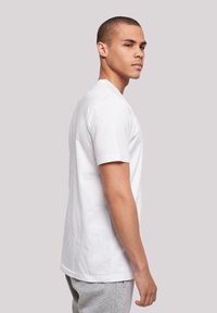 White short-sleeve T-shirt made of cotton. Classic crew neck design with a relaxed fit, smooth texture, and no visible patterns or accents.