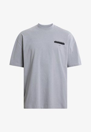 T-shirt en coton gris avec un col rond, des manches courtes, et un texte noir imprimé sur la poitrine gauche. Présente une coupe décontractée et une texture douce.
