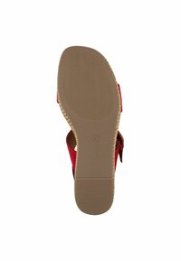 Sandale rouge avec un dessus texturé, une sangle ajustable et une semelle en caoutchouc beige présentant un motif ondulé. Taille indiquée comme 37.